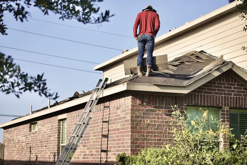 Professional roofer working on a residential roof in Hewlett Neck